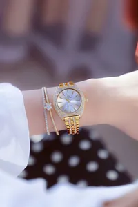 Detalle de elegante reloj de lujo dorado con bisel de diamantes y pulsera a juego