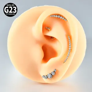 Close-up of G23 titanium curved ear piercings with cubic zirconia on silicone ear model