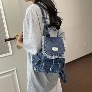 Vista posteriore di uno zaino in denim vintage con volant in pizzo bianco su modella.