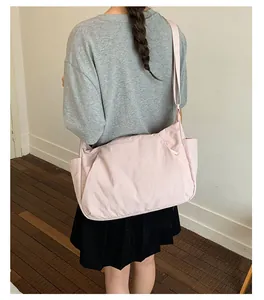 Back view of a model wearing a large pink crossbody bag with a minimalist design.