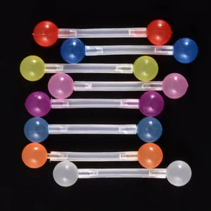 Ensemble de piercings colorés en acrylique pour la langue et le mamelon sur fond noir.