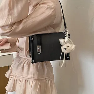 Stylish black women's pillow bag with cute plush bear charm detail and silver hardware