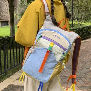 Detailed view of a colorful dopamine-style hiking backpack for women being worn in an outdoor park.