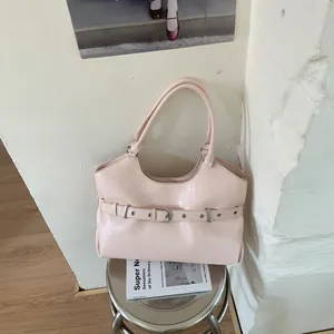 Detail view of pink glossy tote bag with decorative belt buckle detail