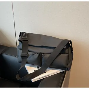 Urban multi-pocket messenger bag for sports and travel displayed on a modern black sofa