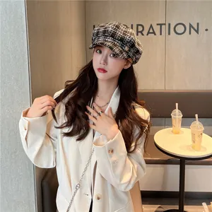 Chic black and white checkered newsboy cap worn by a model in a stylish cafe setting.