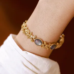 Primer plano de un elegante reloj dorado con pulsera de concha de abulón iridiscente