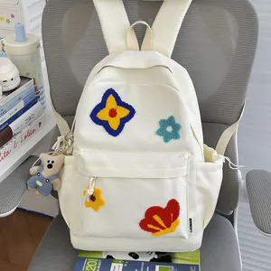 Cream white school backpack with colorful flower embroidery and a cute teddy bear charm