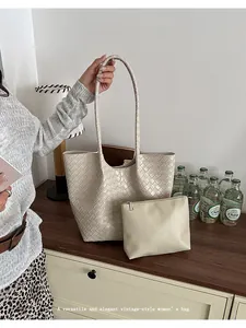Close-up of a stylish and elegant beige woven tote bag with a matching small pouch