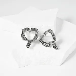Vista detallada de expansores de oreja de acero con calaveras en forma de corazón