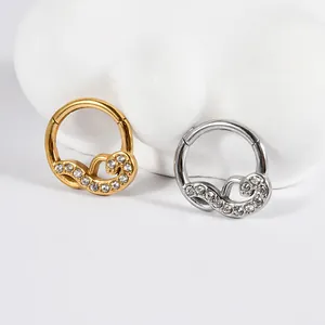 Close-up of stainless steel piercing rings with white zircon in gold and silver finish