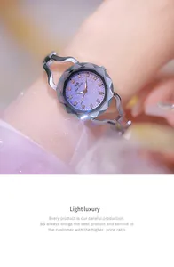 Close-up of elegant purple bracelet watch with rhinestone markers and sparkling dial.