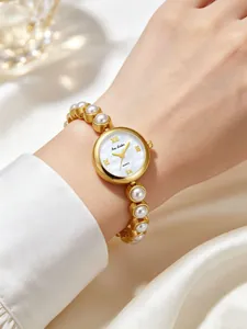 Elegante Bee Sister Gold Quarzuhr mit Perlenarmband an einem weiblichen Handgelenk