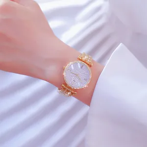Reloj de lujo dorado para mujer con esfera de pedrería completa y pulsera de cristal.