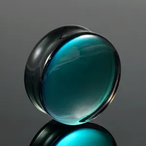 Close-up of a solid teal and black AB glass saddle ear plug with reflective finish.