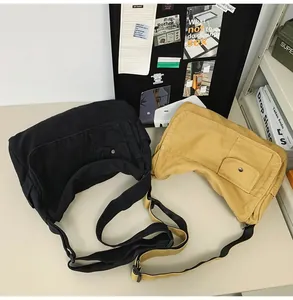 Two minimalist canvas messenger bags in black and yellow shown on a desk