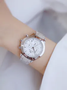 Primer plano detallado de un reloj de mujer clásico en acero plateado con esfera blanca de tres ojos