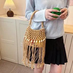 Detailed view of handmade macrame bucket bag with long fringes and bead accents