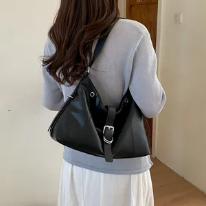Rear view of a woman wearing a stylish black hobo shoulder bag with buckle detail