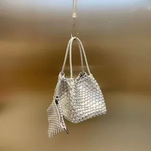 Detailed shot of a minimalist silver metallic woven bucket bag with hanging zip pouch