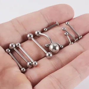 Primo piano di vari gioielli per piercing in acciaio inossidabile su un palmo della mano