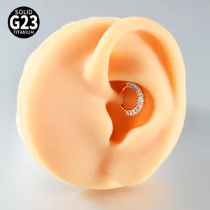 Nahaufnahme eines G23-Titan-Segmentrings mit Baguette-Zirkonia am Ohrmodell