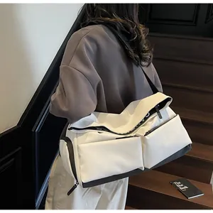 Large white crossbody sports bag with multiple pockets shown worn over the shoulder