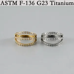 Nahaufnahme von G23 Titan Septum-Ringen mit weißen Zirkonia in Gold und Silber