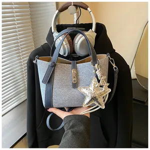 Close-up of a light blue bucket bag with a stylish silver star and balloon dog charm