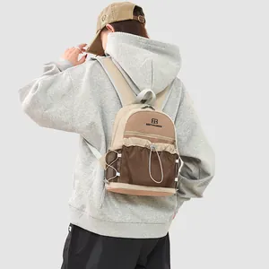 Vue de dos d'une personne portant un sac à dos d'extérieur beige et marron léger