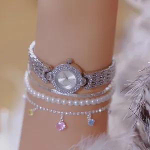 Close-up detail of a luxury silver women's watch with rhinestone bezel and bracelets
