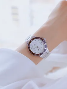 Elegante reloj de acero inoxidable plateado para mujer con esfera blanca puesto en la muñeca
