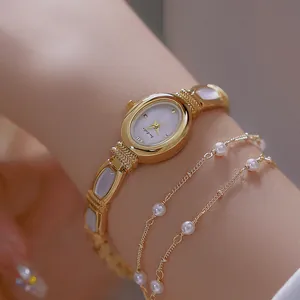 Elegante reloj de mujer dorado ovalado con esfera de nácar e incrustaciones de concha