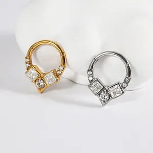 Detail view of gold and silver hinged segment rings with white cubic zirconia stones.