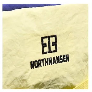Makro-Detailaufnahme des bestickten Northnansen E13 Logos auf dem Outdoor-Rucksack
