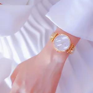 Primer plano de reloj dorado BS Bee Sister con diamantes de imitación en la muñeca.