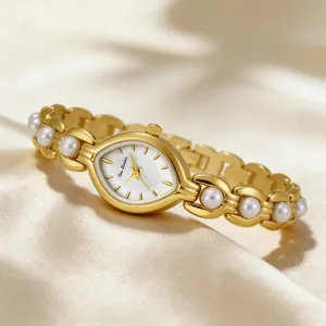 Primo piano di un elegante orologio da donna dorato con perle finte