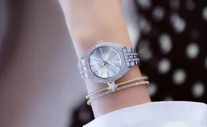 Primer plano de un reloj de cuarzo plateado de lujo para mujer con cristales en la muñeca