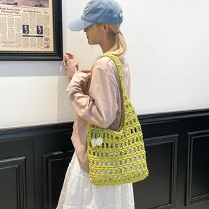 Primer plano de un bolso de ganchillo verde tejido a mano con un atuendo primaveral