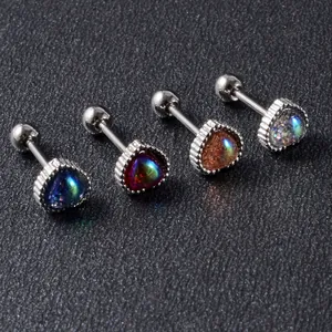 Close-up of four iridescent heart stud earrings with screw back on dark background.