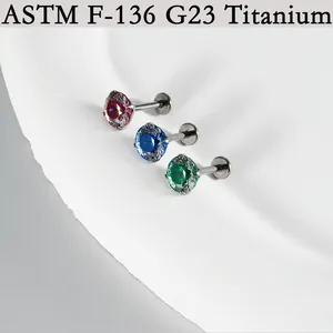 Detail view of G23 titanium labret studs featuring red, blue, and green zircon stones