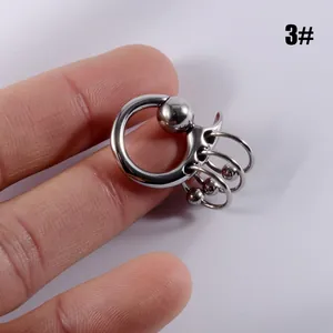 Gros plan d'un bijou anneau à bille captive en acier inoxydable avec charmes suspendus