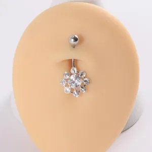 Vista detallada de un piercing de ombligo de acero inoxidable con piedras de circonia brillantes