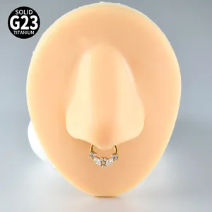Detailansicht eines G23-Titan-Septum-Rings in Gold mit funkelnden Markise-Zirkonia-Steinen.