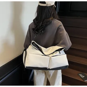 Back view of a woman carrying a stylish white multi-pocket crossbody travel bag on stairs.