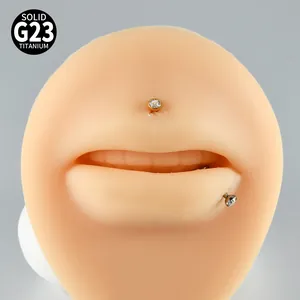 Close-up of G23 titanium lip studs with round zircon on a silicone model.