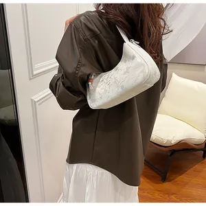 Fashion model wearing white marbled hobo bag with brown leather jacket and skirt