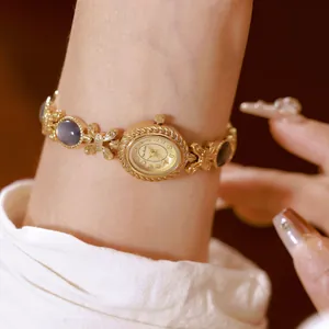 Primer plano de reloj de pulsera dorado con incrustaciones de concha de abalón natural