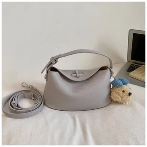Elegant grey pebbled leather bucket bag with top handle and cute puppy charm detail