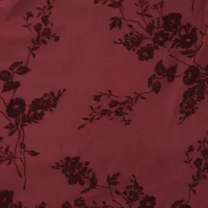 Gros plan macro sur un tissu en maille bordeaux avec d'élégants motifs floraux noirs
